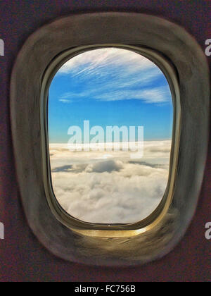 Nuvole e cielo attraverso la finestra di aeroplano Foto Stock