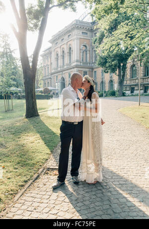 Caucasian sposa giovane kissing all'aperto Foto Stock