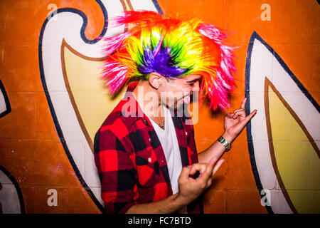 Uomo ispanico indossando parrucca colorata Foto Stock