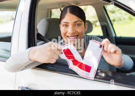 Felice driver femmina sistemando il suo allievo conducente segno Foto Stock