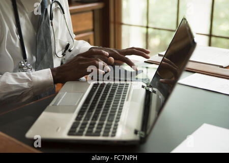 Medico nero utilizzando digitale compressa in office Foto Stock