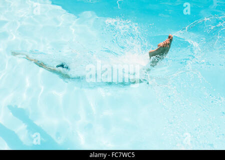 La donna caucasica immersioni in piscina Foto Stock