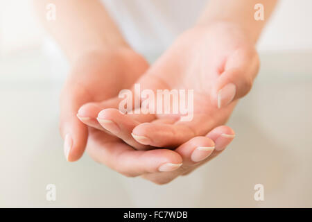 Stretta di mano a tazza di donna ispanica Foto Stock