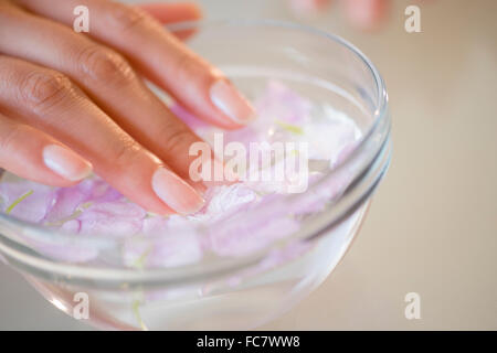 Close up donna ispanica in ammollo i suoi chiodi Foto Stock