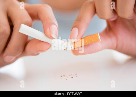 Close up donna ispanica sigaretta di rottura Foto Stock