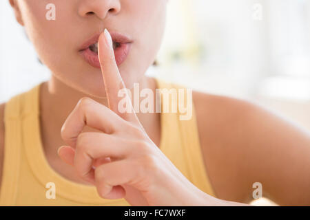 Close up donna ispanica shushing Foto Stock