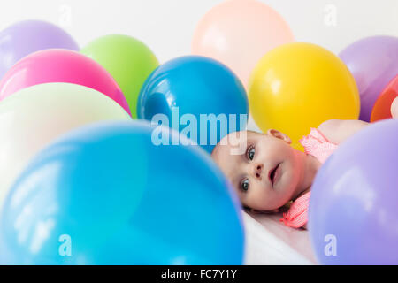 Caucasian Baby girl posa in palloncini Foto Stock