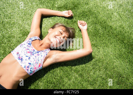 Razza mista donna posa in erba Foto Stock