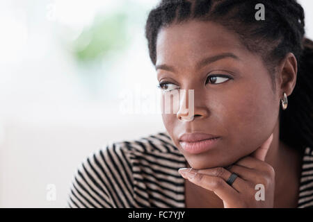 Donna nera mento di appoggio in mano Foto Stock