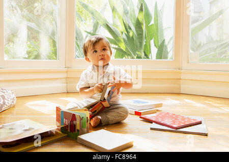 Razza mista baby boy giocando sul pavimento Foto Stock