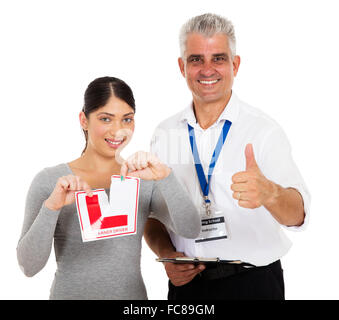 Felice istruttore di guida dando pollice in alto e allievo conducente strappando l segno Foto Stock