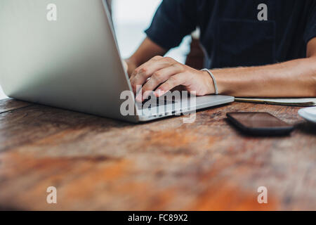 Uomo caucasico utilizzando laptop a tavola Foto Stock