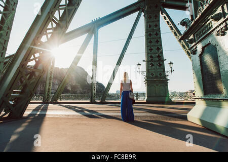 Caucasian donna in piedi sul ponte Foto Stock