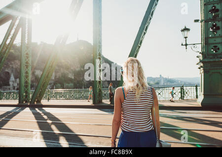 Caucasian donna in piedi sul ponte Foto Stock