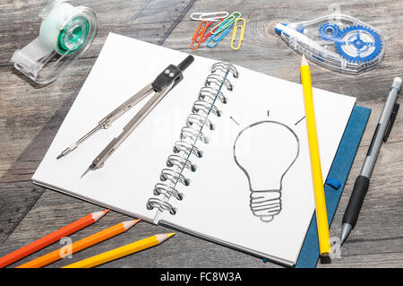 Il disegno di una lampadina su un blocco note Foto Stock