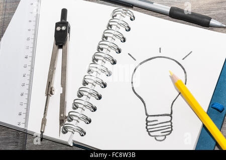 Il disegno di una lampadina su un blocco note Foto Stock