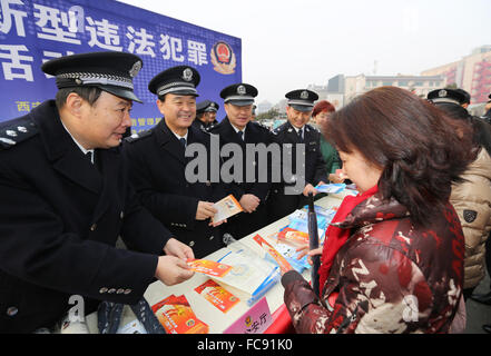 Xi'an. Xxi gen, 2016. Gli ufficiali di polizia mano anti-criminalità informatica volantini ai residenti nei pressi della Torre Campanaria a Xi'an, capitale della Cina nord-occidentale della provincia di Shaanxi. Diversi metodi sono stati usati per rivelare i criminali' inganno mezzi e quindi aumentare la consapevolezza del pubblico in generale contro la criminalità informatica. Credito: Shao Rui/Xinhua/Alamy Live News Foto Stock