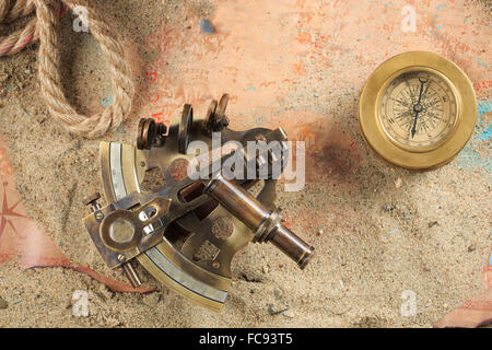 Set di strumenti nautici, distesi sulla sabbia e mappa vecchia. concetto avventura Foto Stock