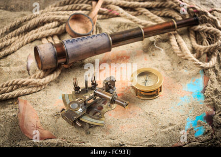 Set di strumenti nautici, distesi sulla sabbia e mappa vecchia. concetto avventura Foto Stock