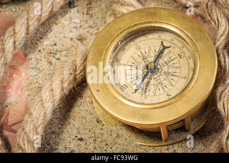 Set di strumenti nautici, distesi sulla sabbia e mappa vecchia. concetto avventura Foto Stock