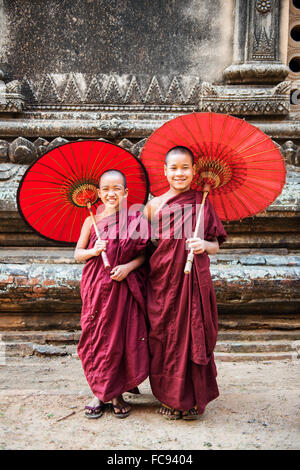 Due giovani monaci e ombrelloni tradizionali, Bagan (pagano), Myanmar (Birmania), Asia Foto Stock