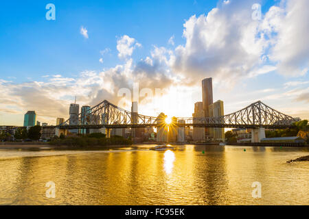 Al tramonto, la città di Brisbane con il sole nascosto dietro il Ponte Story, Brisbane, Queensland, Australia Pacific Foto Stock