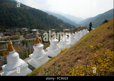 Fila di chortens bianco all'ingresso Rangjung monastero buddista nelle splendide colline sopra Trashigang, Est Bhutan Foto Stock