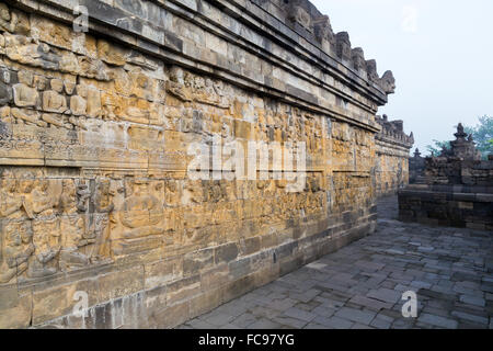 Pannelli di rilievo del tempio di Borobudur in Indonesia. Borobudur è il tempio buddista più grande del mondo. Foto Stock