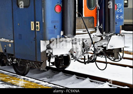 Dettaglio shot con congelati vagone treno tamponi, links di collegamento e ruote in inverno Foto Stock