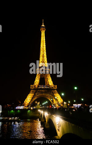 La torre Eiffel di notte illuminato, con Pont d'Iéna ponte sopra Seine, Parigi, Francia. Foto Stock