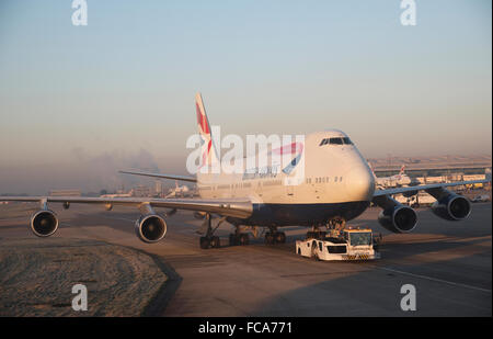 Jet del passeggero che viene spostato mediante un aeromobile trattore a Heathrow Aeroporto di Londra Foto Stock