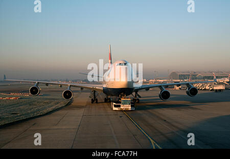 Jet del passeggero che viene spostato mediante un aeromobile trattore a Heathrow Aeroporto di Londra Foto Stock