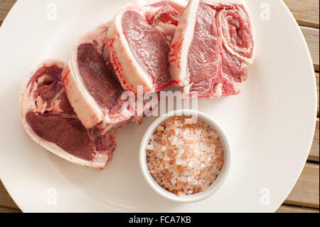 Carni di agnello costolette di carne sulla piastra con sale Foto Stock