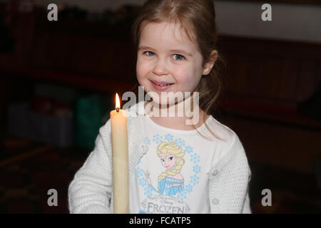 Battesimo presso la chiesa di Saint Mary Caterham sulla collina Surrey in Inghilterra ragazza con il Battesimo candela Foto Stock