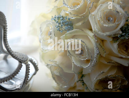 Sposa scarpe e bouquet su uno sfondo bianco. Foto Stock