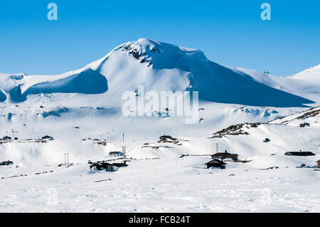 Cottage vicino stazione ferroviaria Finse, ferroviaria Oslo-Bergen, mountain Finsenuten nel retro, inverno, Hordaland, Norvegia Foto Stock