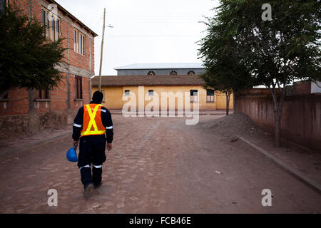 Un minatore passeggiate home su una strada solitaria in una piccola città vicino al Salar de Uyuni in Bolivia. Foto Stock