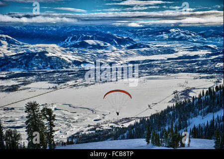 Un parapendio vola sopra una corsa a Jackson Hole Ski Resort in Jackson Hole, Wyoming. Foto Stock