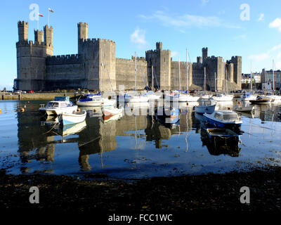 Caernarfon Castle riflettendo in acqua nelle vicinanze Foto Stock