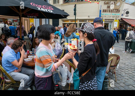 Persone street mangiare patatine fritte patatine fritte Foto Stock