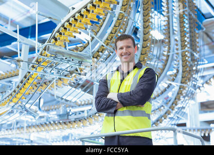 Ritratto fiducioso lavoratore sotto permanente stampa nastri trasportatori tettuccio Foto Stock