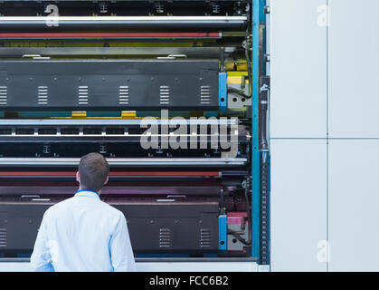 Ingegnere guardando verso l'alto stampa macchinari di impianto di stampa Foto Stock