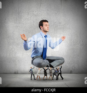 Giovane imprenditore meditando supportati da colleghi di lavoro Foto Stock