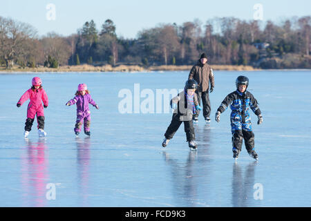 Listerby, Svezia - 17 Gennaio 2016: bambini e adulti sono avente un certo divertimento sul mare ghiacciato ghiaccio. Il ghiaccio è liscia e la landsca Foto Stock