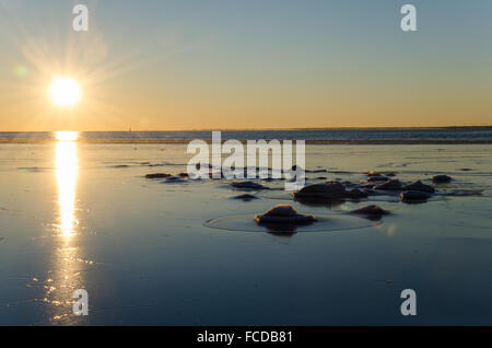 La luce del sole da un gelido e vista rocciose presso la costa di Isola svedese Oland nel Mar Baltico Foto Stock