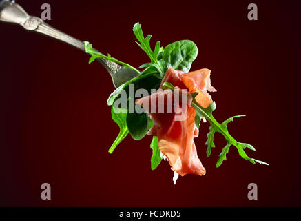 Jamon con spinaci e rucola su sfondo scuro Foto Stock