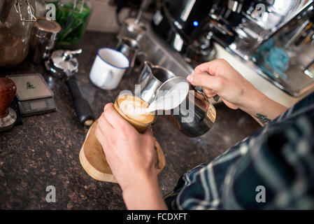 Barista rendendo il Perfetto piatto bianco Foto Stock