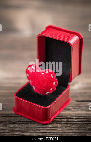 Feltro rosso cuore in scatola anello su sfondo di legno Foto Stock