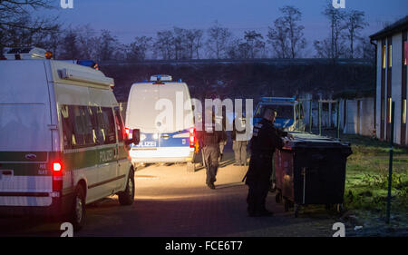 Recklinghausen, Germania. Il 22 gennaio, 2016. Contrassegnate i furgoni di polizia e funzionari di polizia stand durante un raid della polizia a un rifugiato alloggio in facciata di un edificio in Recklinghausen, Germania, 22 gennaio 2016. La polizia ha razziato un alloggio per i rifugiati in cerca di rifugiati illegali. Una polizia spokesperon ha confermato che i funzionari di polizia sono state controllando i dati personali e la documentazione dei profughi. Foto: Marcel Kusch/dpa/Alamy Live News Foto Stock