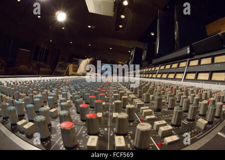 Vista laterale di qualcuno che lavora su un ssl e serie di missaggio del suono di scrivania e Apple Mac con studio di altoparlanti in uno studio di registrazione Foto Stock